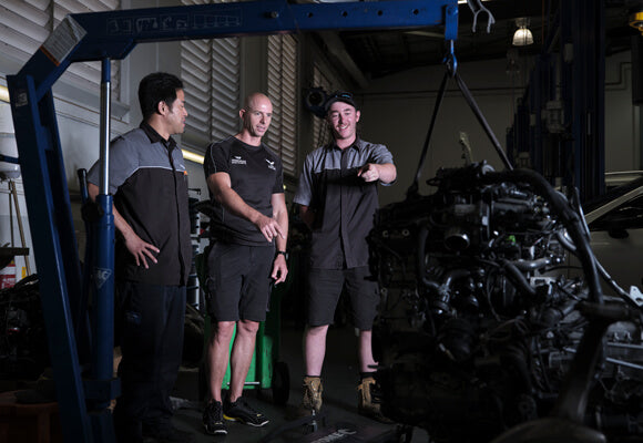 Luke Youlden discussing an engine with mechanics