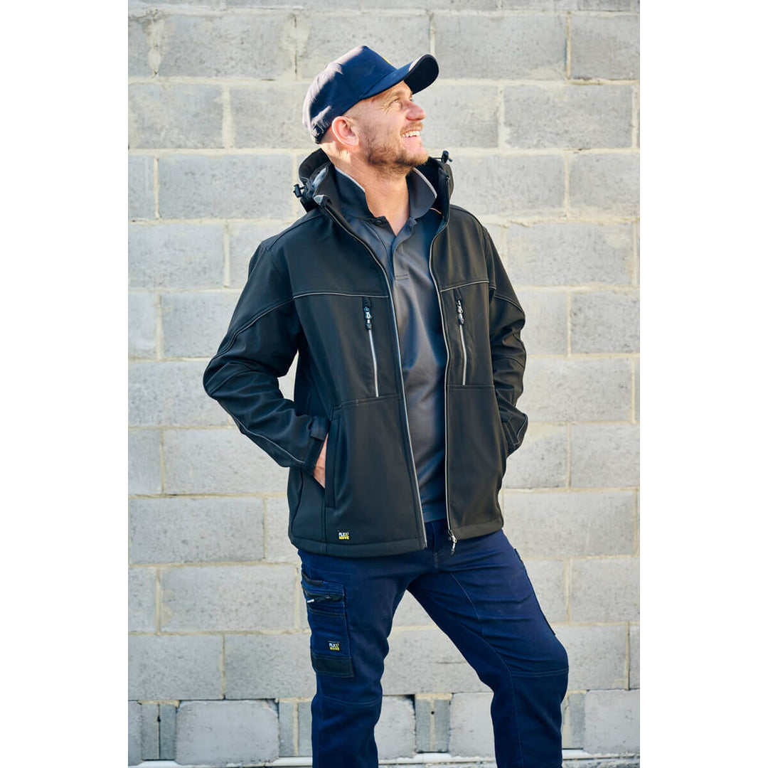 Man wearing a dark jacket and, wearing a Bisley BCAP50 Cap, standing against a gray brick wall