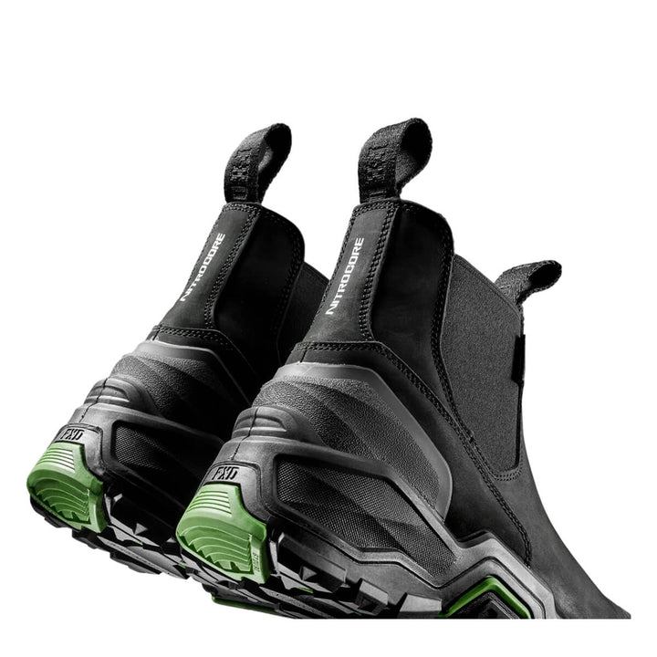 A pair of black boots with chunky black and gray soles and green accents on the outsole, shown on a plain white background.